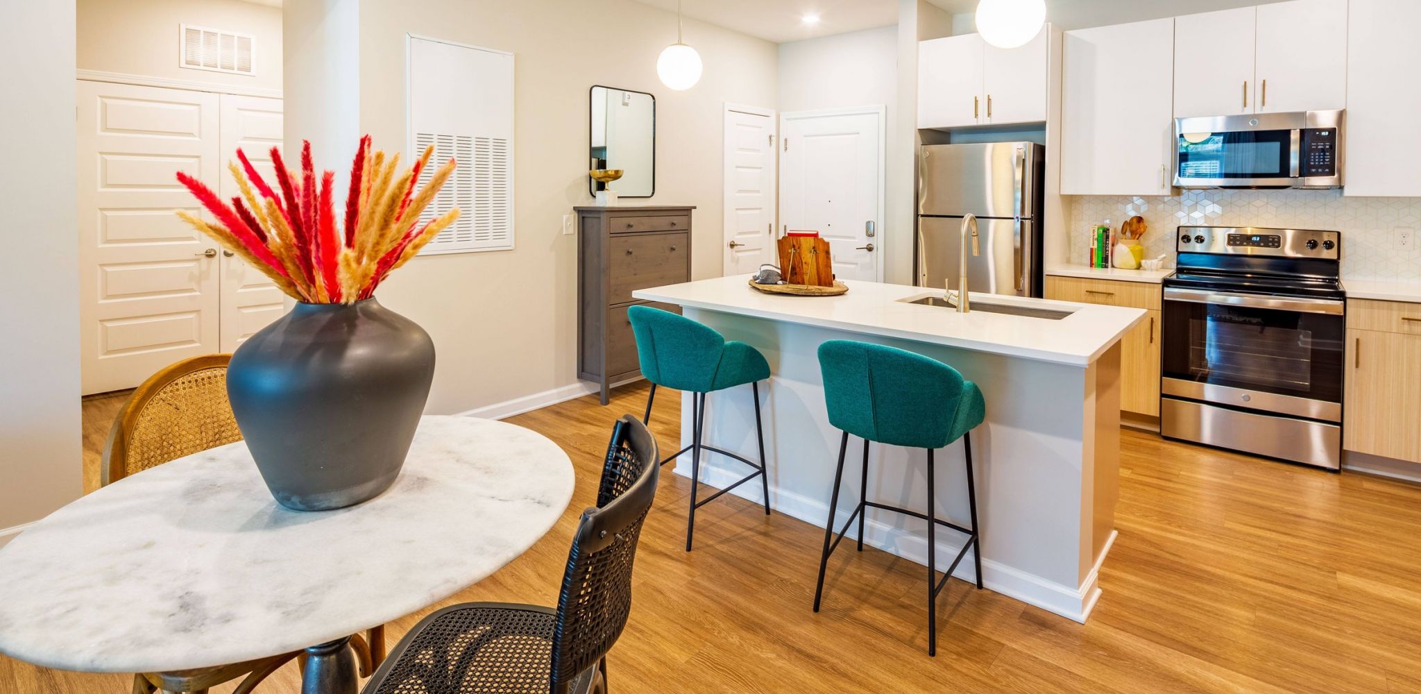 Hawthorne at Oleander beautiful apartment kitchen with kitchen island, stainless steel appliances, tile backsplash, and custom cabinetry