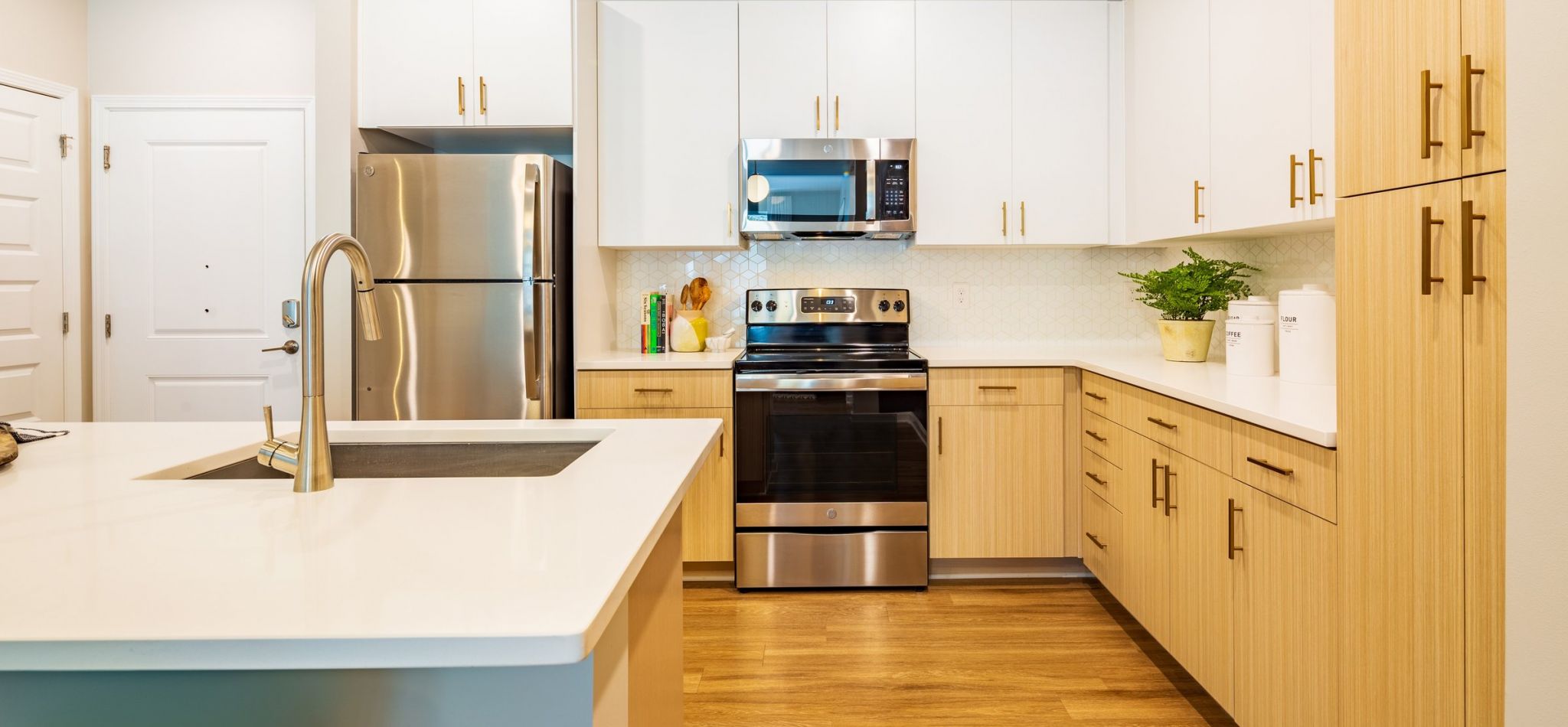 Hawthorne at Oleander luxury apartment kitchen interior with kitchen island, stainless steel appliances, and two-tone cabinetry