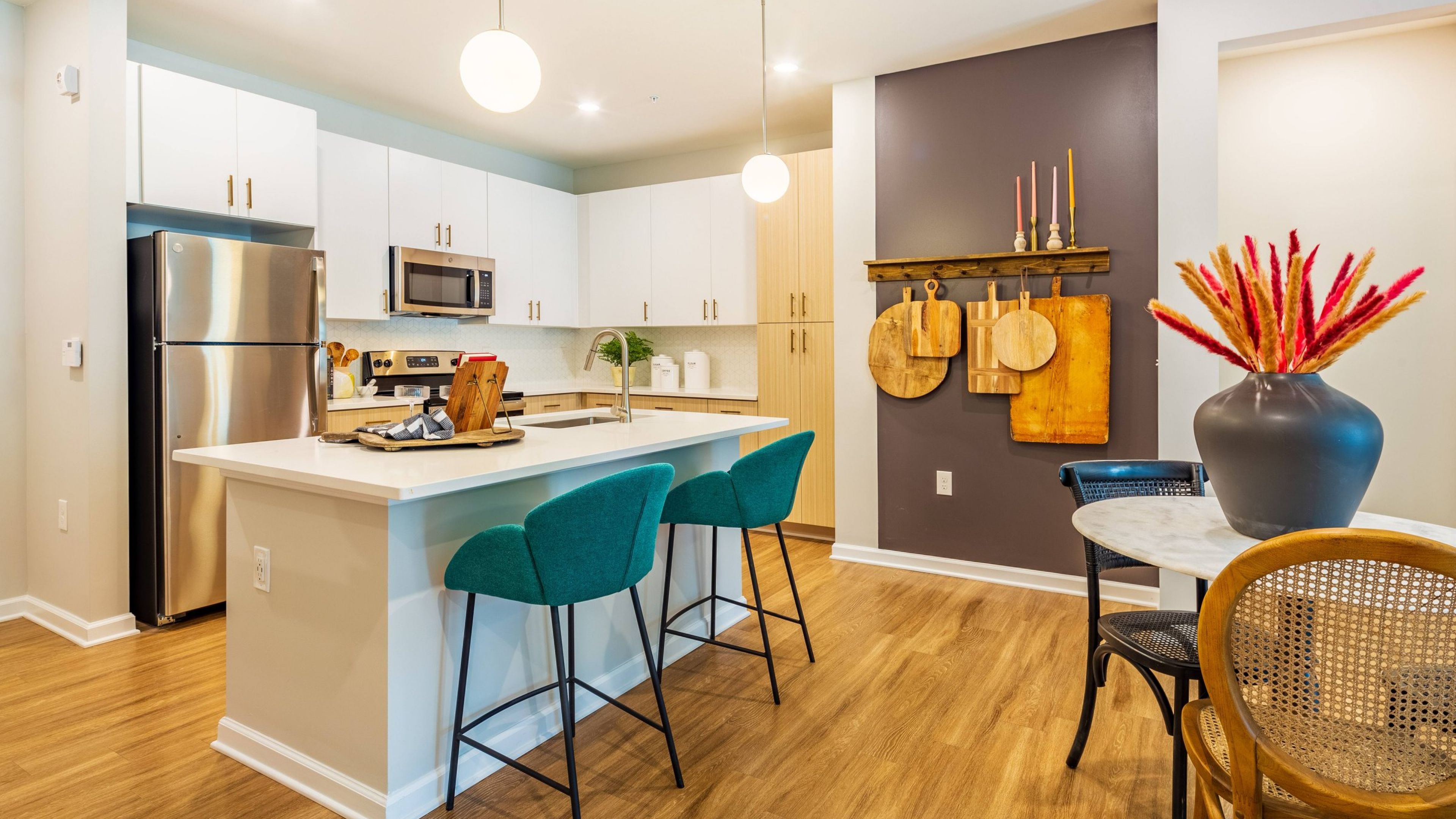 Hawthorne at Oleander apartment living space and kitchen with small dining table, kitchen island, and stainless steel appliances