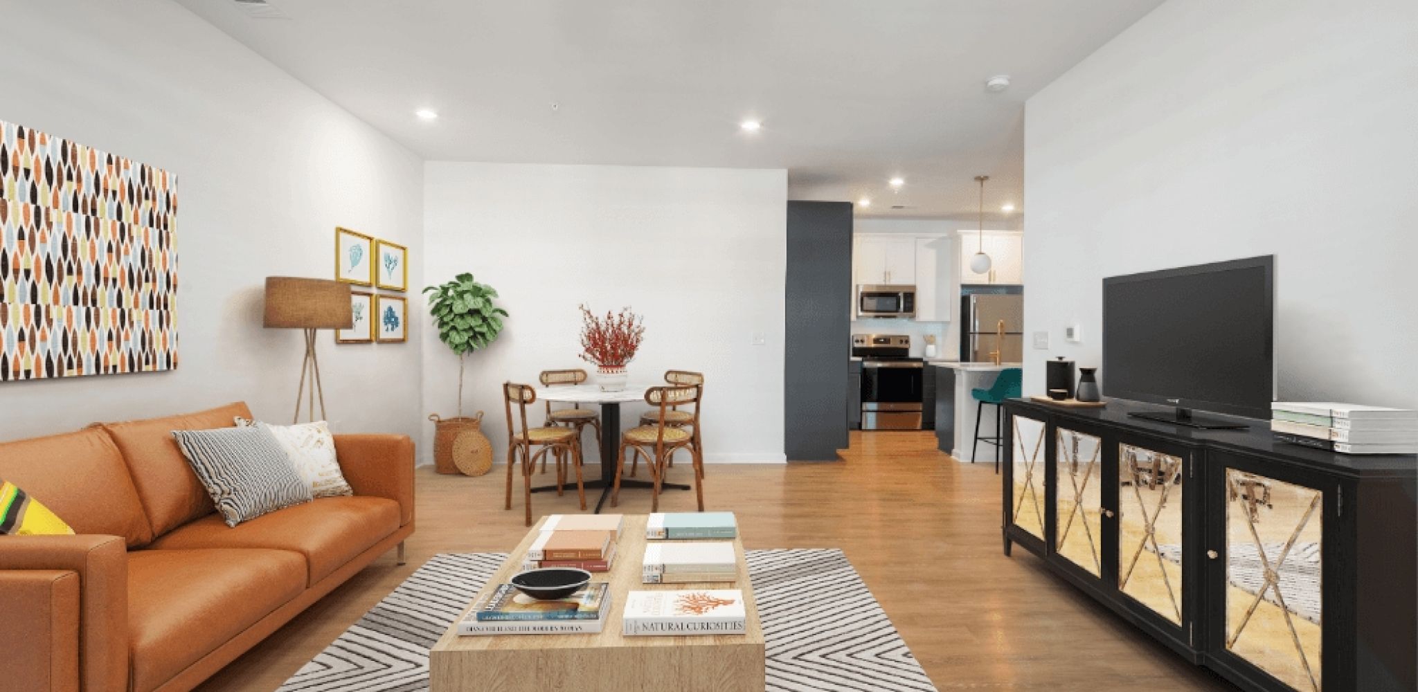 Hawthorne at Oleander apartment living room with hardwood floors, a dining area with small table, and furnished with a couch, coffee table, and TV stand